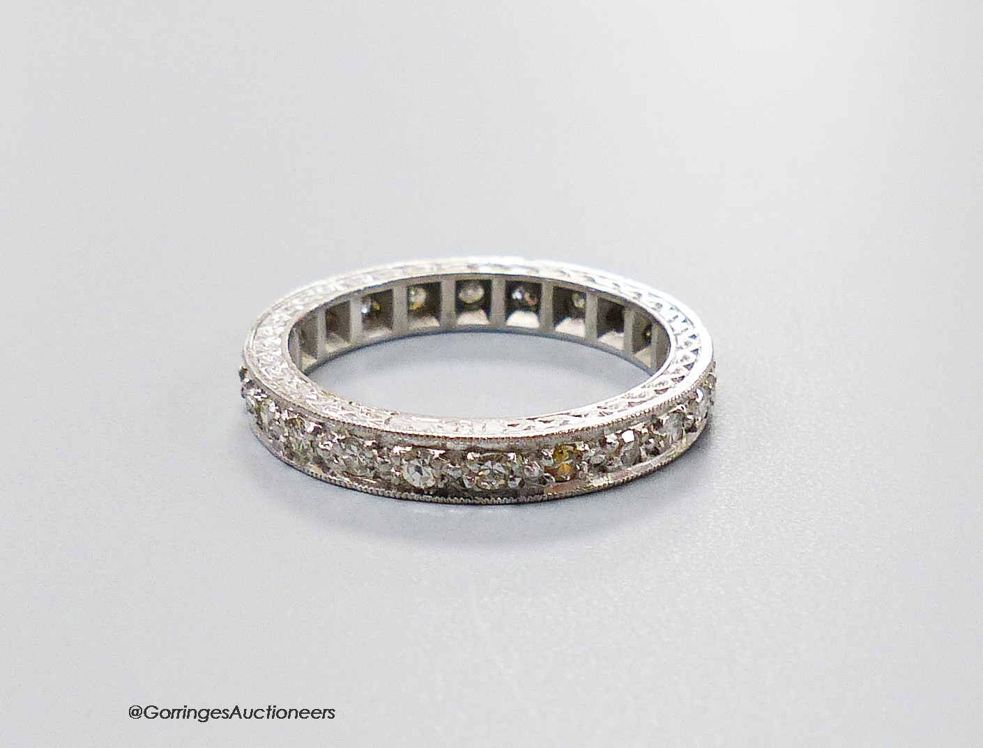 A mid 20th century white metal (stamped 18ct) and diamond set full eternity ring, size M, gross weight 4.8 grams.